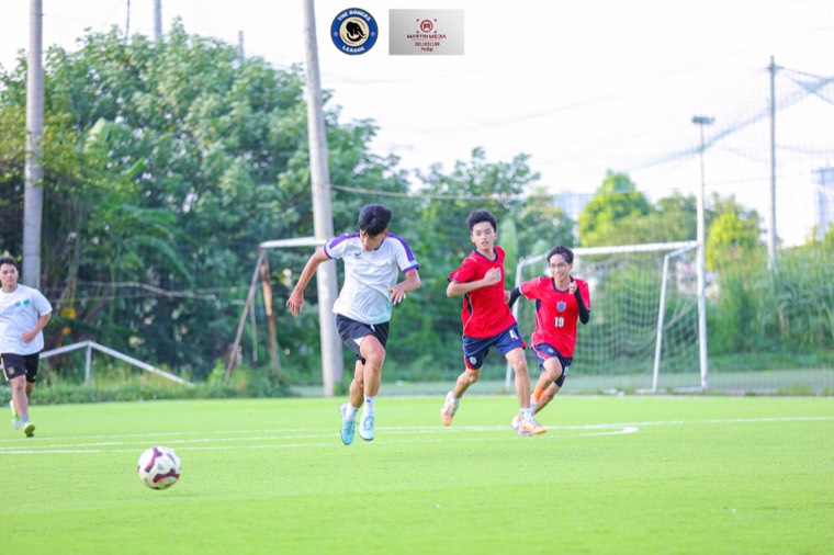 Ba cầu thủ chạy đuổi theo bóng trên sân